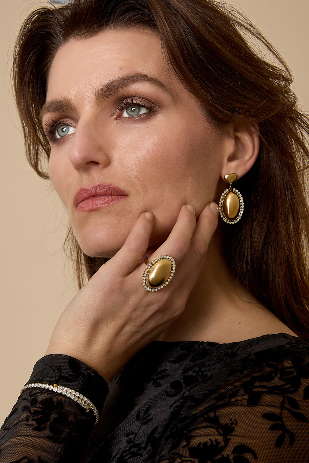 Statement earrings with an oval charm surrounded by stones