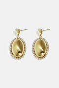 Statement earrings with an oval charm surrounded by stones