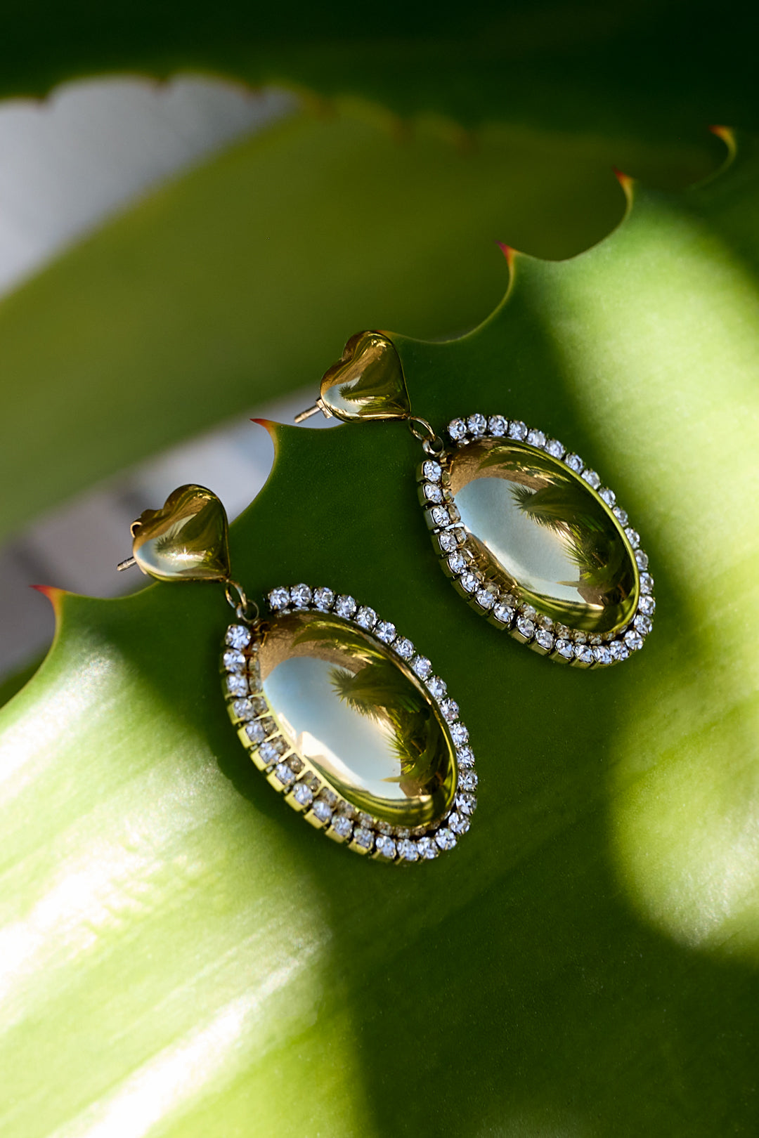 Statement earrings with an oval charm surrounded by stones